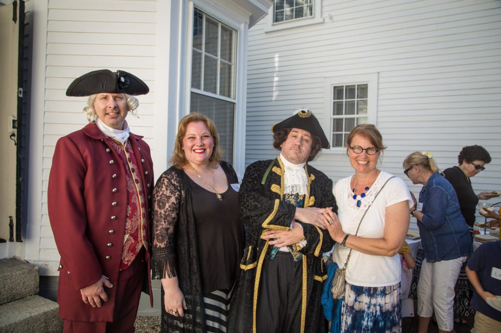people pose with men in colonial garb